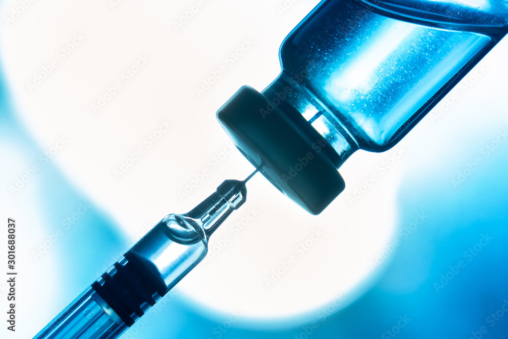Close up of measles and flu vaccine vials for child vaccination, medicine and drug concept Close up of measles and flu vaccine vials for child vaccination, medicine and drug concept