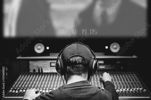 back of asian male professional producer, sound engineer, composer mixing audio track and music score on movie in sound studio. advertising, movie, drama post production concept