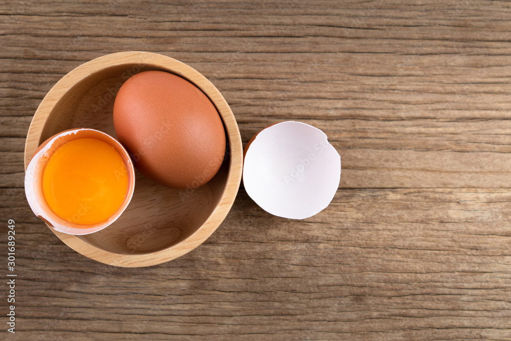 Closeup of raw chicken eggs in egg box on brown wooden background, organic food from nature good for health Closeup of raw chicken eggs in egg box on brown wooden background, organic food from nature good for health