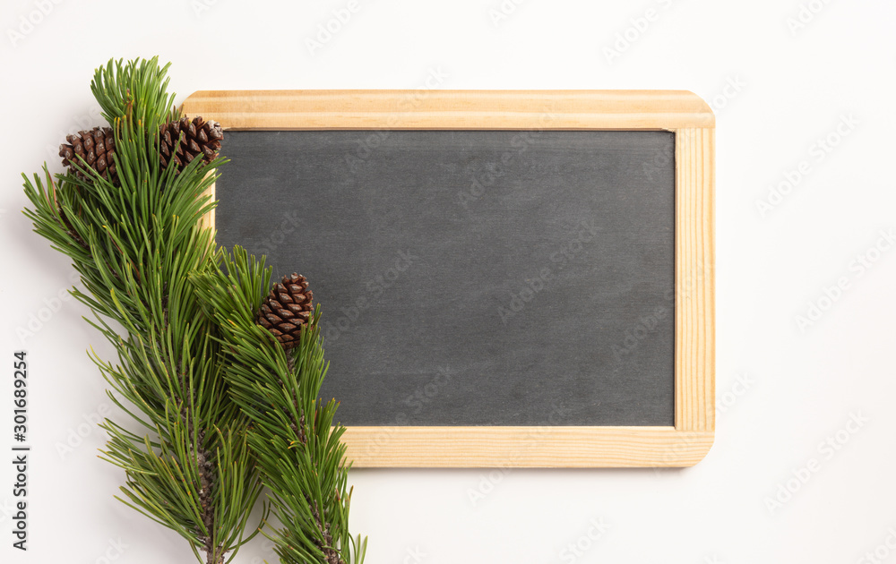 Christmas composition. Spruce branches and blank blackboard, on a white background. Flat lay, top view, copy space.
