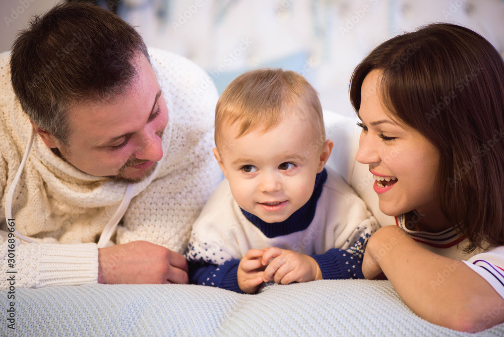 Christmas family. Happy mom,dad and little son lying on the bed. Enjoyng love hugs, holidays people. Christmas family. Happy mom,dad and little son lying on the bed. Enjoyng love hugs, holidays people.