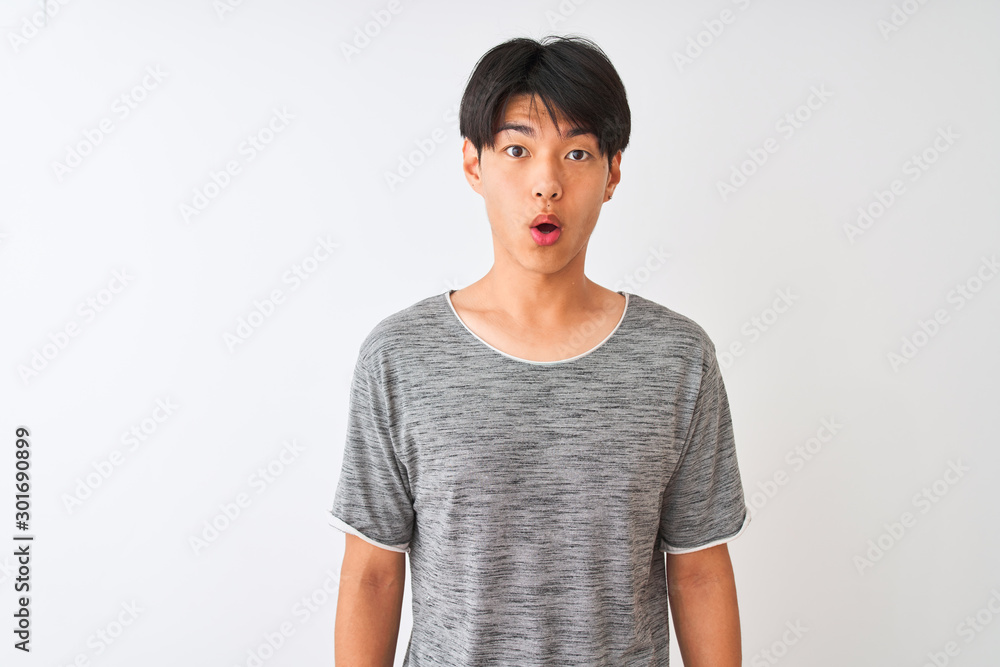 Young chinese man wearing casual t-shirt standing over isolated white background afraid and shocked with surprise expression, fear and excited face. Young chinese man wearing casual t-shirt standing over isolated white background afraid and shocked with surprise expression, fear and excited face.