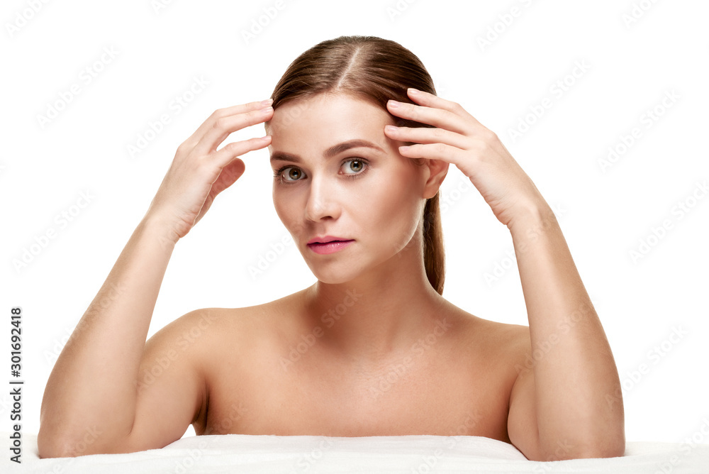 Portrait of young woman with clean fresh skin touching face Portrait of young woman with clean fresh skin touching face