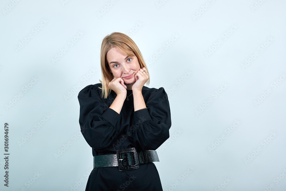 Pretty smiling young woman in casual clothes looking camera, put hands prop up on chin isolated on white wall background. People sincere emotions, lifestyle concept. Pretty smiling young woman in casual clothes looking camera, put hands prop up on chin isolated on white wall background. People sincere emotions, lifestyle concept.