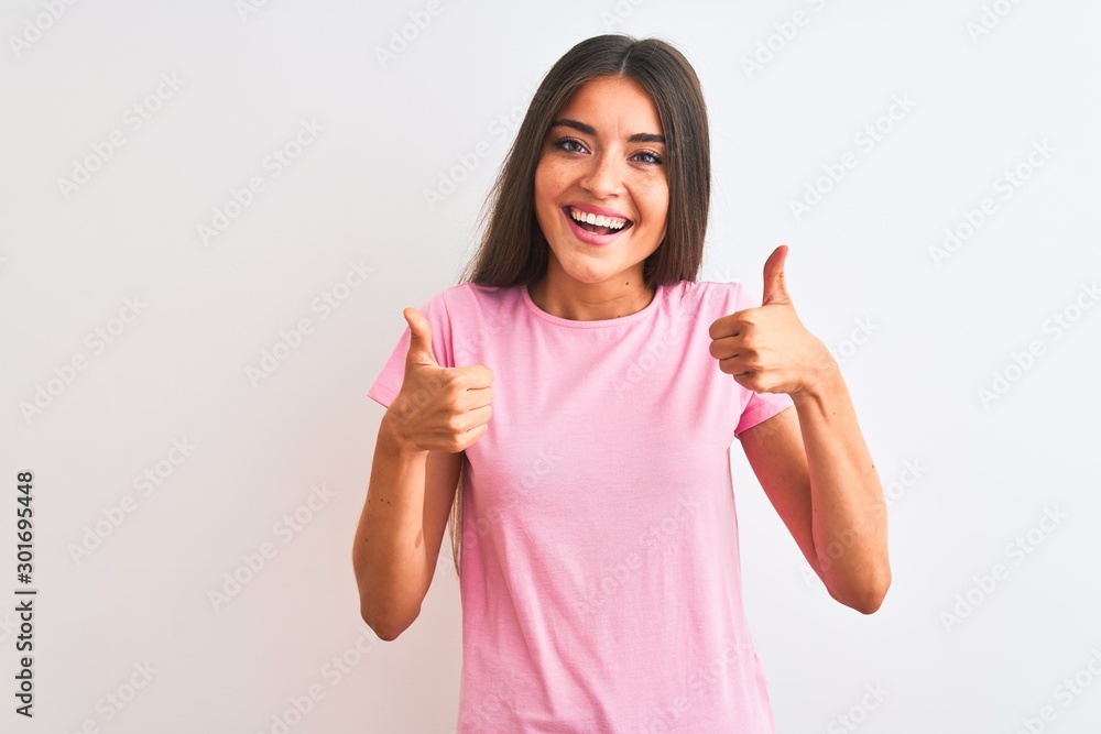 Young beautiful woman wearing pink casual t-shirt standing over isolated white background success sign doing positive gesture with hand, thumbs up smiling and happy. Cheerful expression Young beautiful woman wearing pink casual t-shirt standing over isolated white background success sign doing positive gesture with hand, thumbs up smiling and happy. Cheerful expression