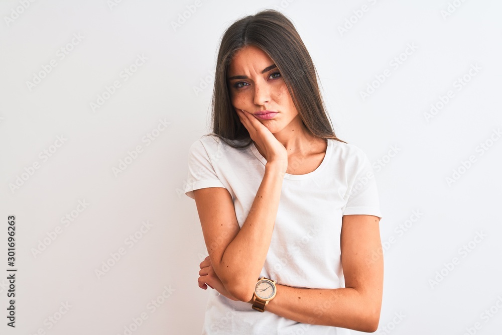 Young beautiful woman wearing casual t-shirt standing over isolated white background thinking looking tired and bored with depression problems with crossed arms. Young beautiful woman wearing casual t-shirt standing over isolated white background thinking looking tired and bored with depression problems with crossed arms.