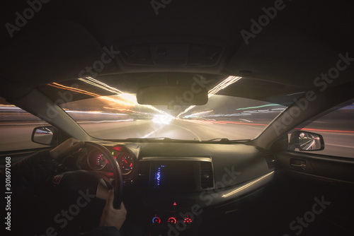 Driver is driving a car on night city road concept. Long exposure photo.