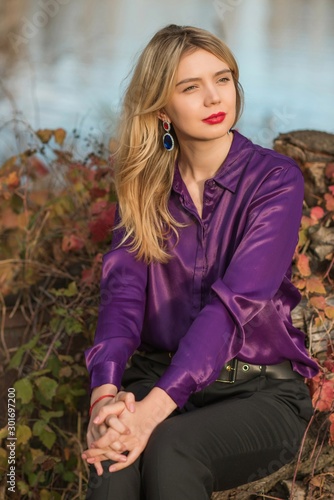 Nice woman, American or European appearance enjoying life. Young lady, stylishly dressed in purple blouse at nature .Natural beauty 