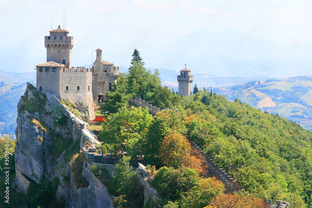 Italy. The landmark of San Marino, a beautiful view of the three towers on the peaks of Mount Monte Titano on a nice summer day with a near and distant plan.