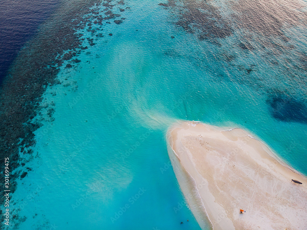 coral beach seen from above by drone in white and turquoise colors - waves visible from the high sensation of movement