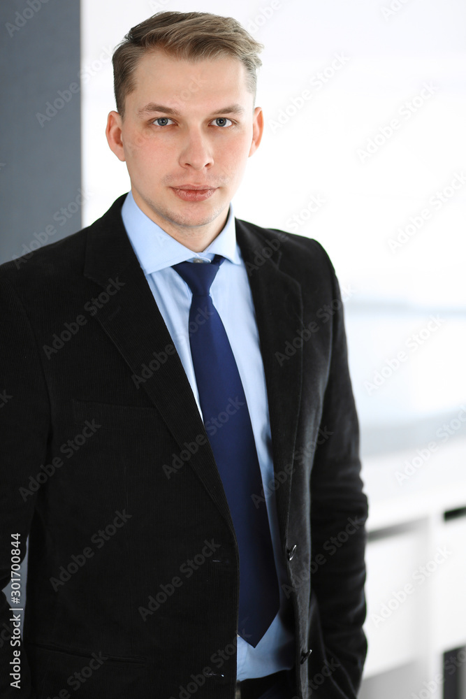Headshot of businessman standing straight in office. Success and business workplace concept Headshot of businessman standing straight in office. Success and business workplace concept