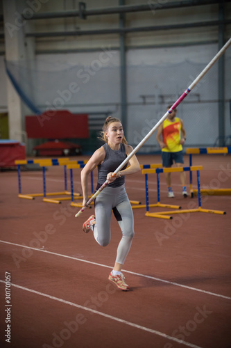Pole vaulting - woman is running with a long pole in her hands
