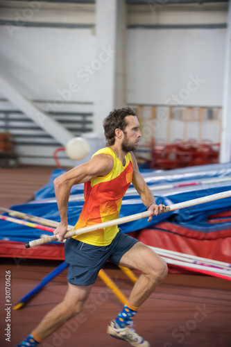 Pole vaulting - man is running with pole in hands
