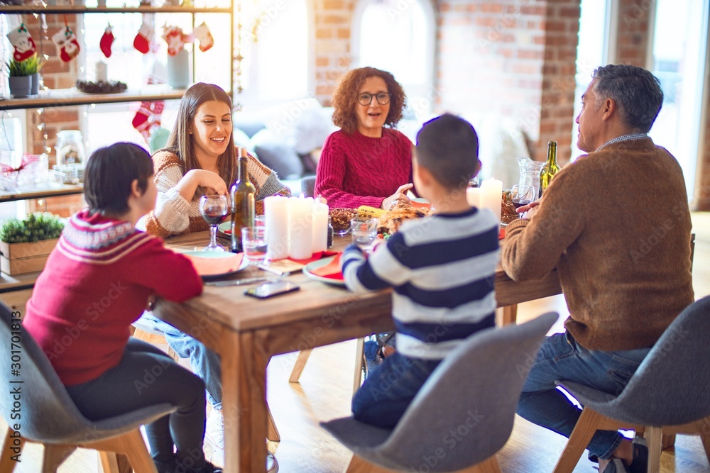 Fototapeta premium Beautiful family smiling happy and confident. Eating roasted turkey celebrating christmas at home