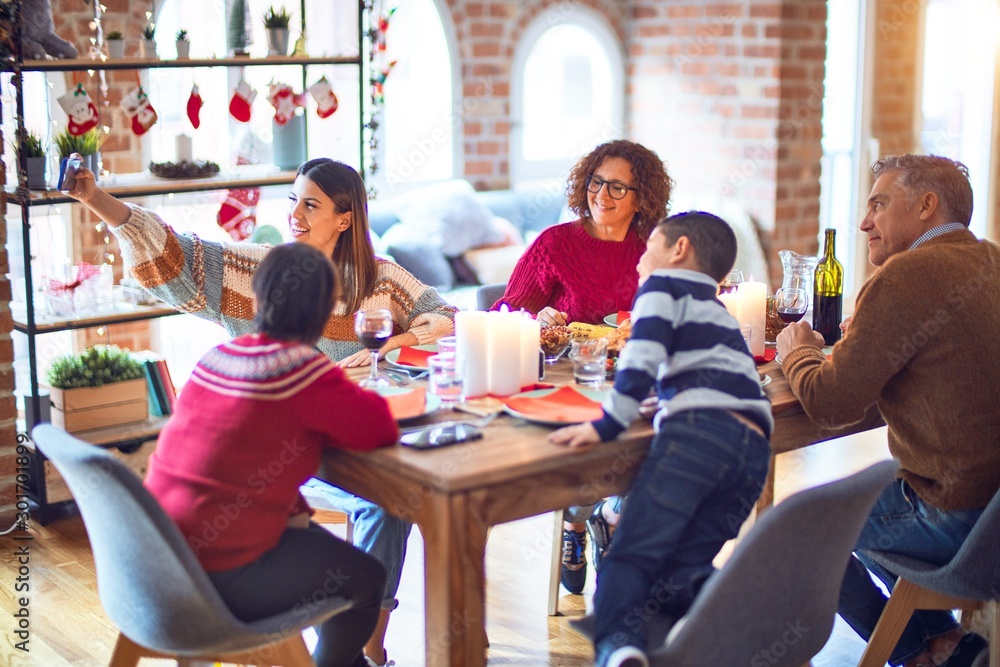 Beautiful family smiling happy and confident. Eating roasted turkey make selfie by smartphone celebrating christmas at home Beautiful family smiling happy and confident. Eating roasted turkey make selfie by smartphone celebrating christmas at home