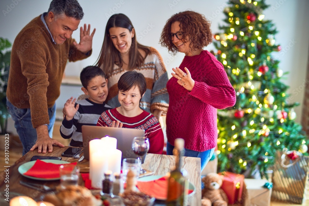 Beautiful family smiling happy and confident. Eating roasted turkey make videocall using laptop celebrating christmas at home Beautiful family smiling happy and confident. Eating roasted turkey make videocall using laptop celebrating christmas at home