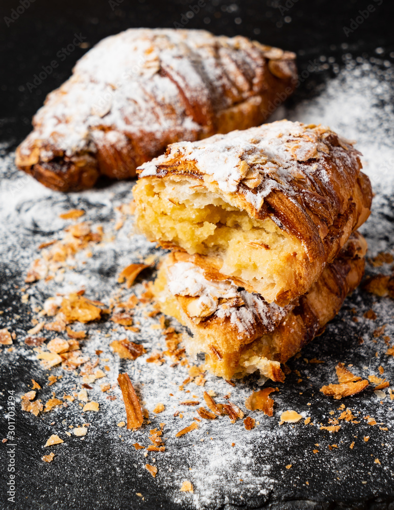 Fototapeta premium Croissants with almonds on the black background