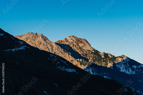 Wallpaper Mural Beautiful sunset view of a mountain alpine landscape of Totes Gebirge, Austria. High alpine peaks in yellow and orange evening light. Rocky summit and rock walls of alpine peaks. Blue sky. Torontodigital.ca