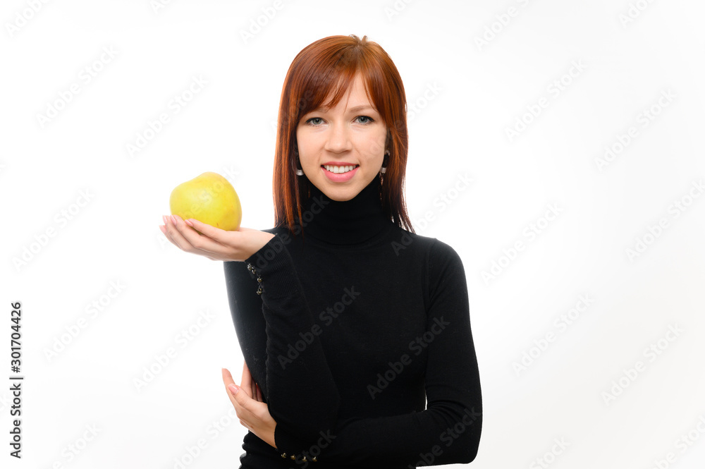 Healthy food concept. Portrait of a pretty red-haired student girl with long smooth hair on a white background in a black sweater with an apple in her hands. Talking, showing emotions, smiling. Healthy food concept. Portrait of a pretty red-haired student girl with long smooth hair on a white background in a black sweater with an apple in her hands. Talking, showing emotions, smiling.