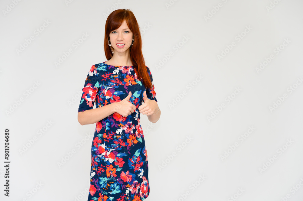 Portrait of a pretty woman, red-haired student girl with long straight hair on a white background in a multi-colored dress. Talking to the camera, showing emotions, smiling. Portrait of a pretty woman, red-haired student girl with long straight hair on a white background in a multi-colored dress. Talking to the camera, showing emotions, smiling.