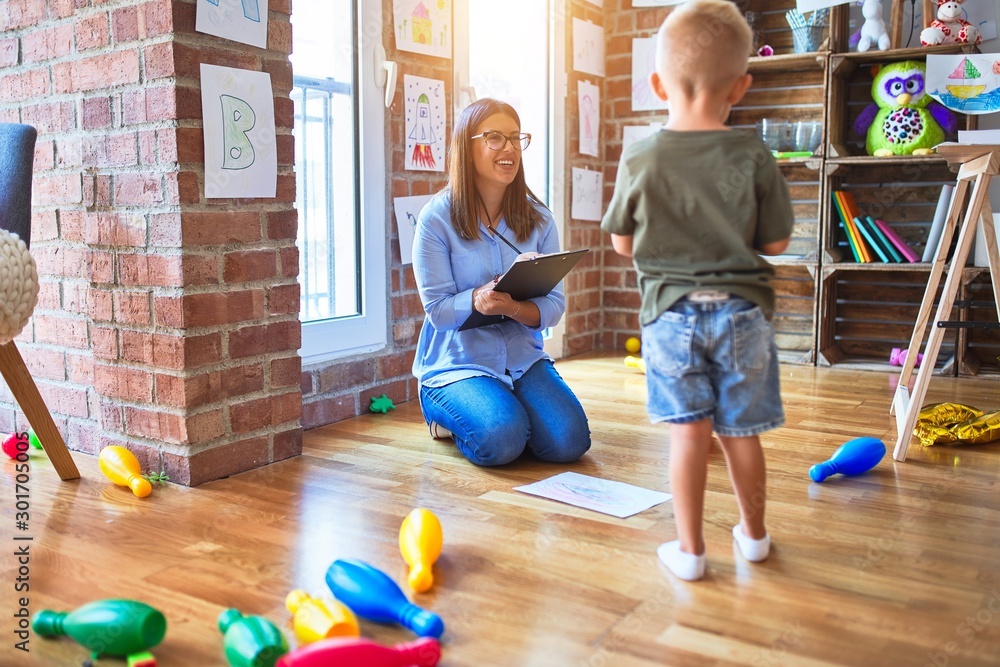 Young therapist woman speaking with child, counselor and behaviour correction at the office around toys