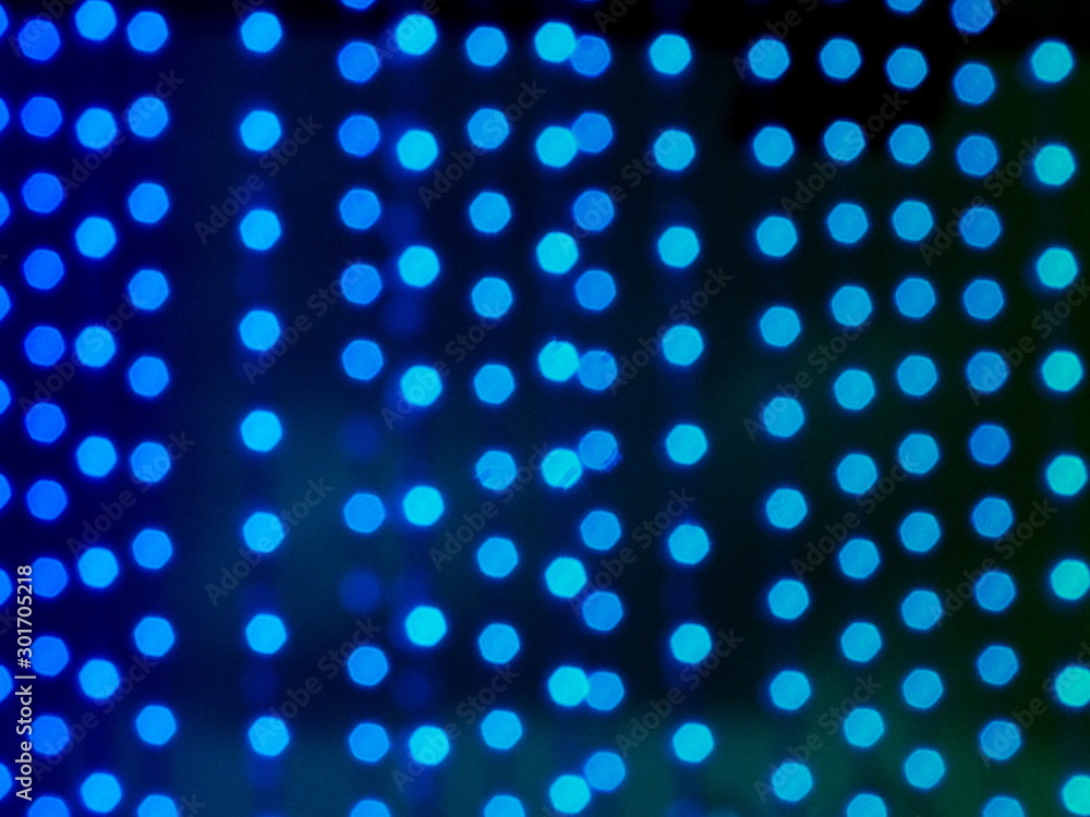 Blue bokeh background of defocused glittering lights.