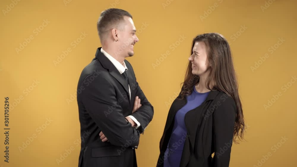 Business people man and woman talking against yellow background Business people man and woman talking against yellow background