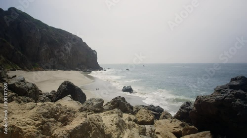 Waves crash along a rocky beach in Malibu photo