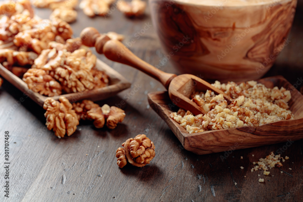 Walnuts in a wooden dish on an old wooden table. Walnuts in a wooden dish on an old wooden table.