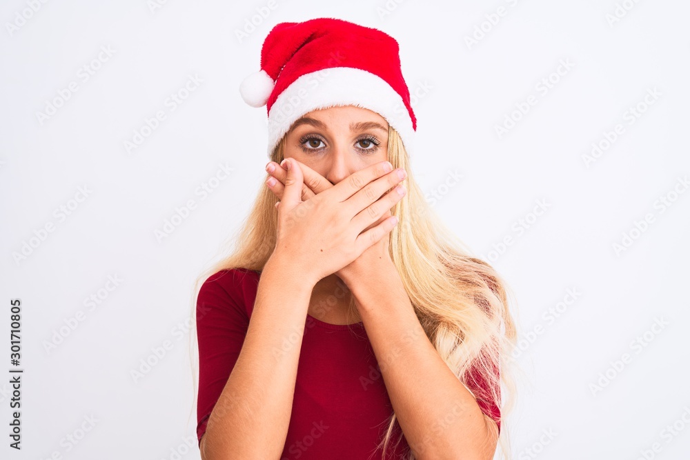 Young beautiful woman wearing Christmas Santa hat over isolated white background shocked covering mouth with hands for mistake. Secret concept. Young beautiful woman wearing Christmas Santa hat over isolated white background shocked covering mouth with hands for mistake. Secret concept.