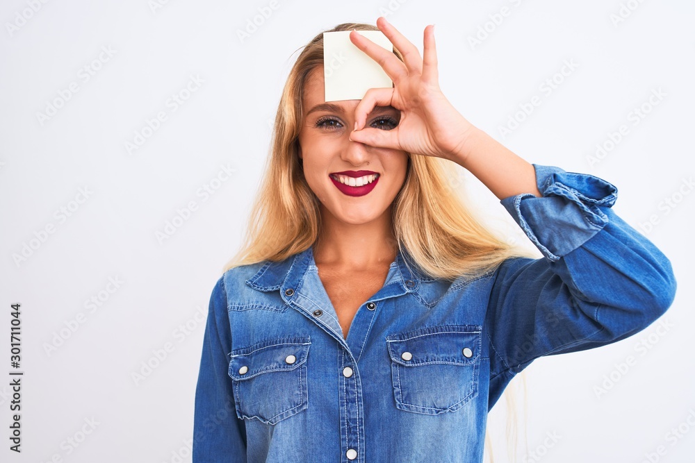 Beautiful woman with reminder sticker paper on forehead over isolated white background with happy face smiling doing ok sign with hand on eye looking through fingers Beautiful woman with reminder sticker paper on forehead over isolated white background with happy face smiling doing ok sign with hand on eye looking through fingers