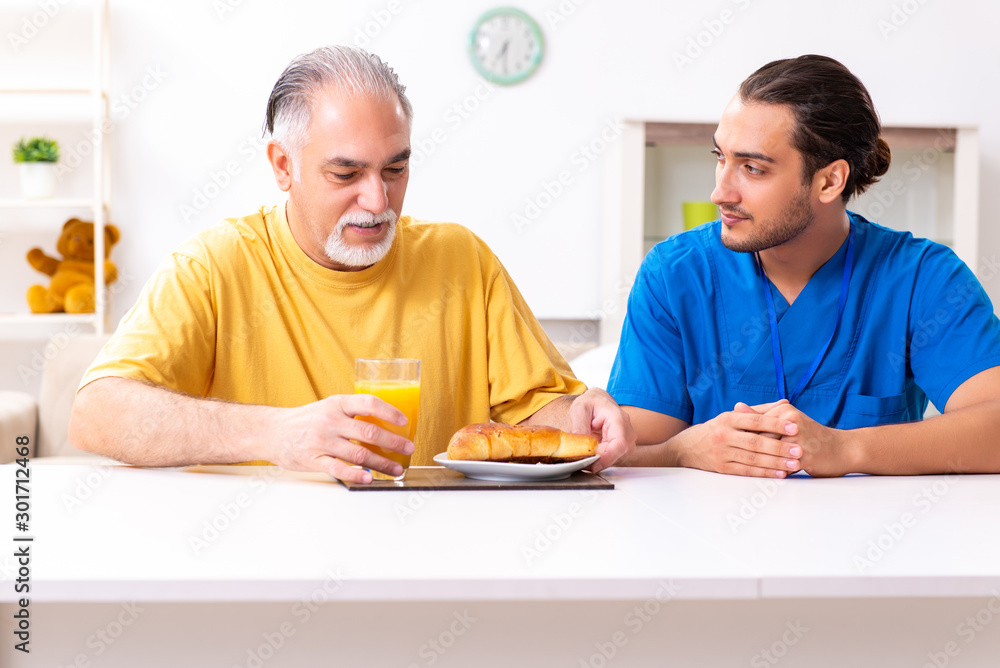 Young male doctor visiting old patient at home Young male doctor visiting old patient at home