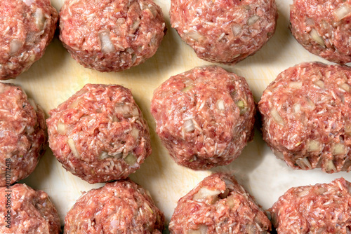 Raw balls of ground beef with spices for the preparation of hamburgers, meatballs.