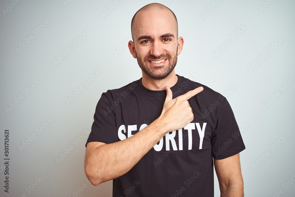 Young safeguard man wearing security uniform over isolated background cheerful with a smile of face pointing with hand and finger up to the side with happy and natural expression on face Young safeguard man wearing security uniform over isolated background cheerful with a smile of face pointing with hand and finger up to the side with happy and natural expression on face