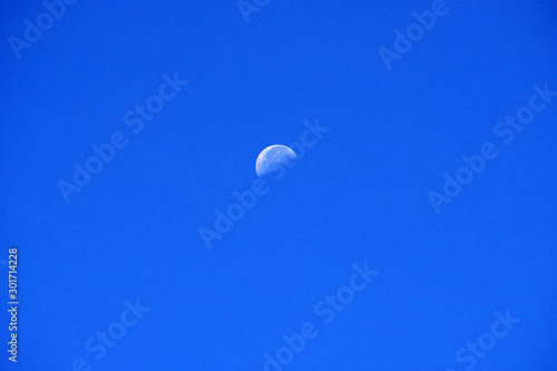 Nature scene of the moon in day time isolated with blue sky background - minimal abstract patterns 