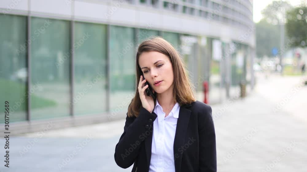 Portrait of a young woman walking and talking on the phone Portrait of a young woman walking and talking on the phone