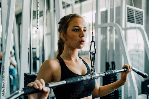 Young Fitness Woman Execute Exercise on a Machine at the Gym.
