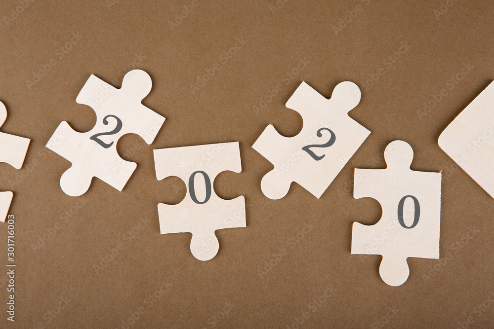 Fototapeta premium Puzzle pieces with text 2020 on a brown background