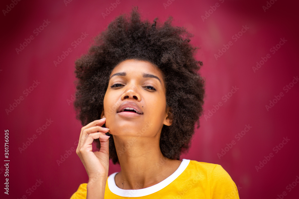 CLose up beautiful african american female fashion model with afro hairstyle by red background CLose up beautiful african american female fashion model with afro hairstyle by red background