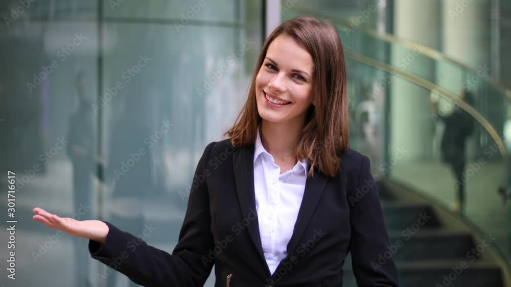 Young businesswoman welcoming you in a modern city setting Young businesswoman welcoming you in a modern city setting