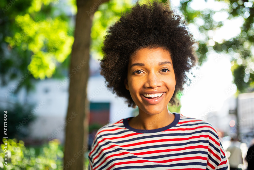 Close up beautiful young black woman laughing with afro hair in park Close up beautiful young black woman laughing with afro hair in park