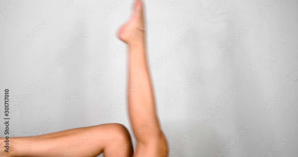 A Pair of Woman's Legs Making Cyclic Movements and Stretching Isolated on White A Pair of Woman's Legs Making Cyclic Movements and Stretching Isolated on White