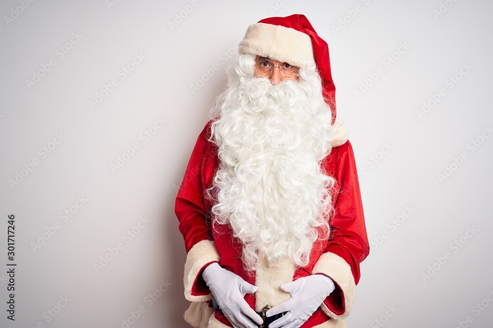 Middle age handsome man wearing Santa costume standing over isolated white background depressed and worry for distress, crying angry and afraid. Sad expression.