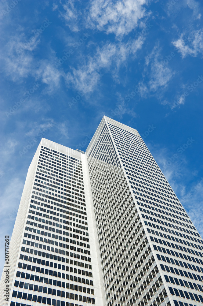 Anonymous white office tower skyscraper standing outdoors in bright blue sky Anonymous white office tower skyscraper standing outdoors in bright blue sky