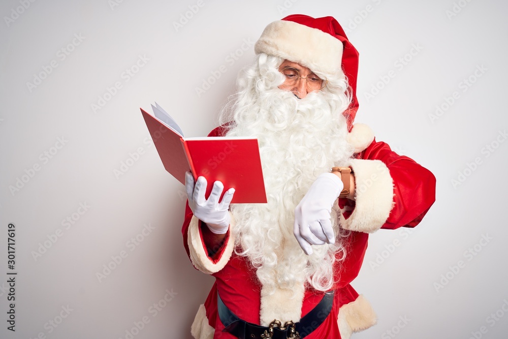 Middle age man wearing Santa Claus costume reading book over isolated white background Checking the time on wrist watch, relaxed and confident Middle age man wearing Santa Claus costume reading book over isolated white background Checking the time on wrist watch, relaxed and confident