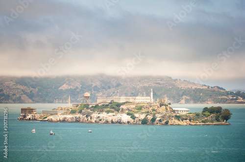 View of Alcatraz Island and its infamous prison from San Francisco with fog clinging to the hills in the background