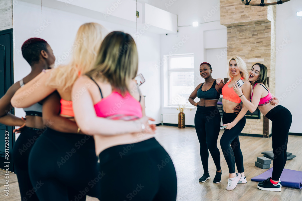 Friends grimacing after working out in fitness studio Friends grimacing after working out in fitness studio