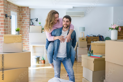 Young couple moving to a new house, boyfriend giving a piggy back ride to girlfriend, very happy and cheerful for new apartment