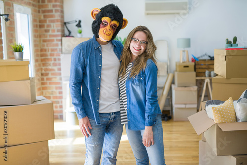 Photography Young couple having fun wearing a monkey mask moving to a new apartment around c