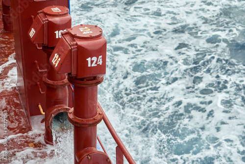 View of Ballast Water exchange process onboard of a ship using flow-through method underway in open ocean. Overflow method through ballast tank air head.